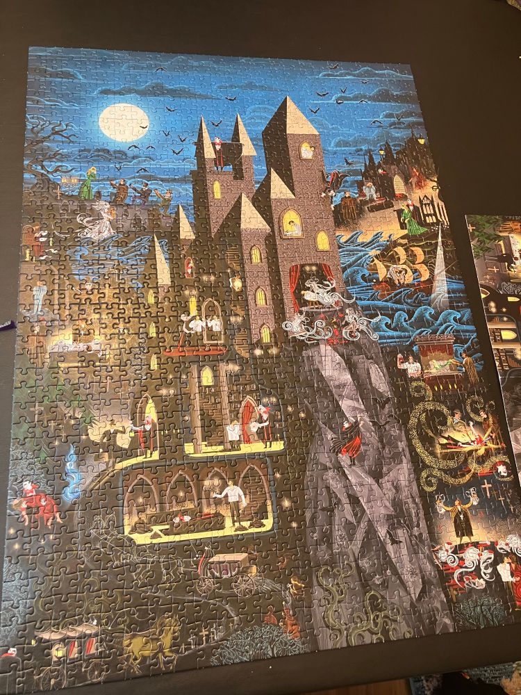 A large completed puzzle the center is a castle and in and around it are scenes from the novel Dracula