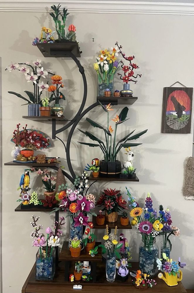 A tiered shelf displaying mostly floral Lego creations 