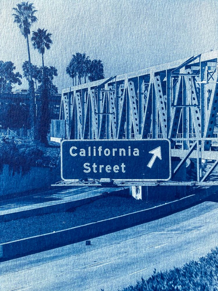Cyanotype view of California st exit sign on freeway hanging under railroad bridge over freeway