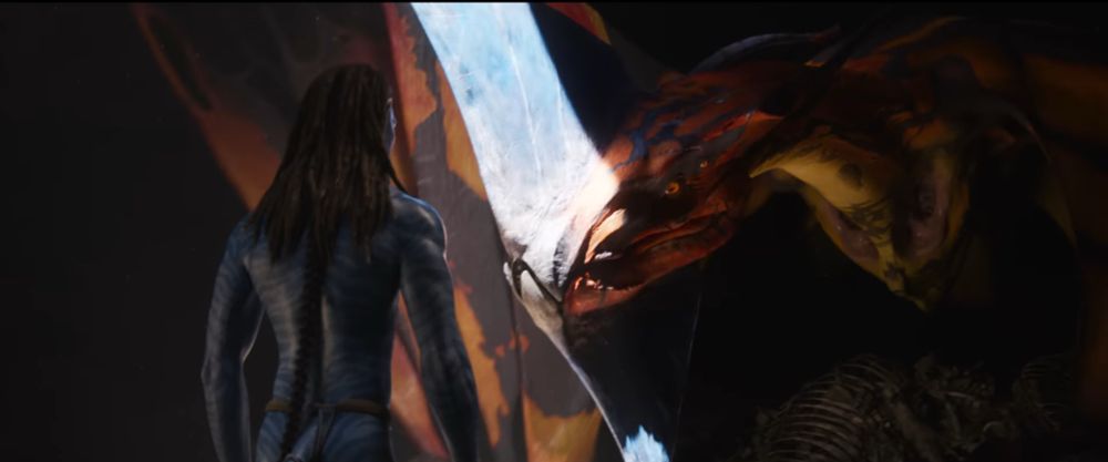 Jake and Toruk together in a cave. Dark lighting except for a single line of sunlight pouring into the cave.