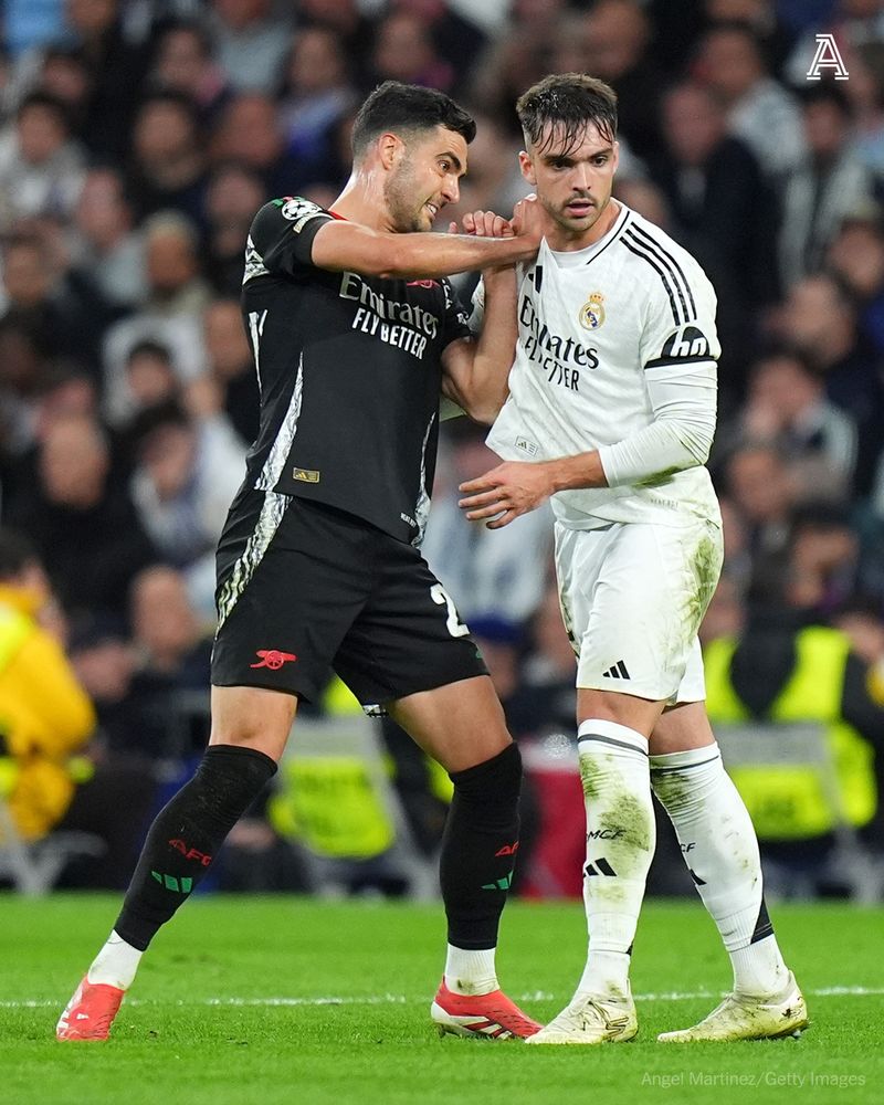 MADRID, SPAIN - APRIL 16: Mikel Merino of Arsenal and Raul Asencio of Real Madrid battle off the ball during the UEFA Champions League 2024/25 Quarter Final Second Leg match between Real Madrid C.F. and Arsenal FC at Estadio Santiago Bernabeu on April 16, 2025 in Madrid, Spain. (Photo by Angel Martinez/Getty Images)