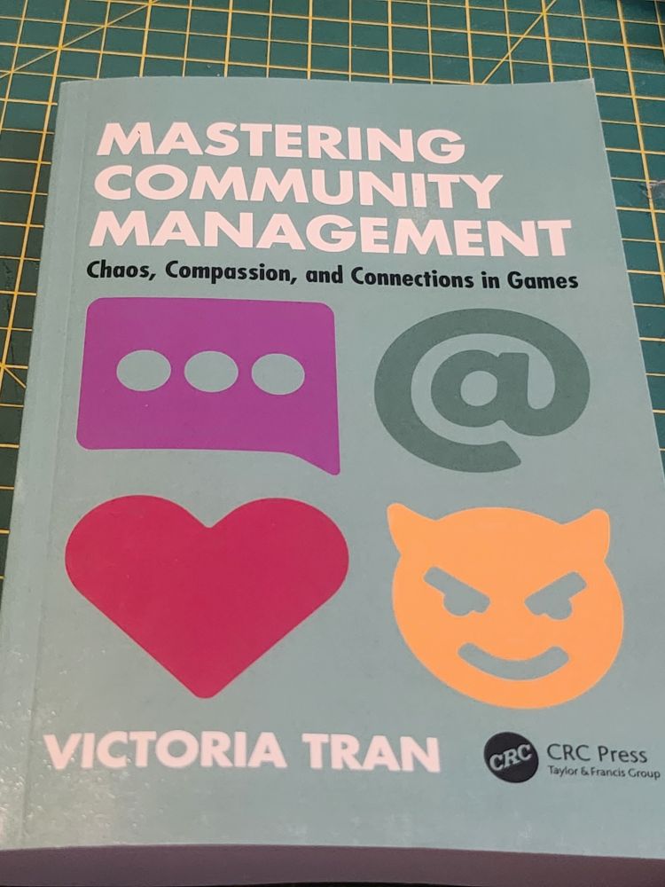 Copy of the book "Mastering Community Management" by Victoria Tran on a table.