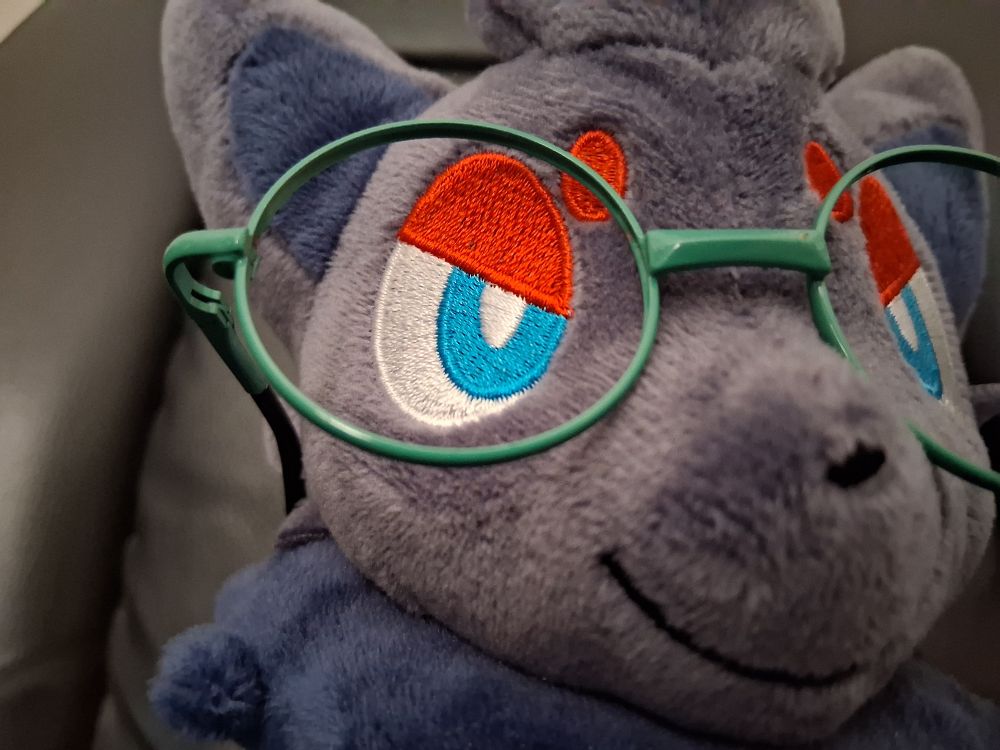 closeup of a zorua plush wearing my ralsei plush's glasses