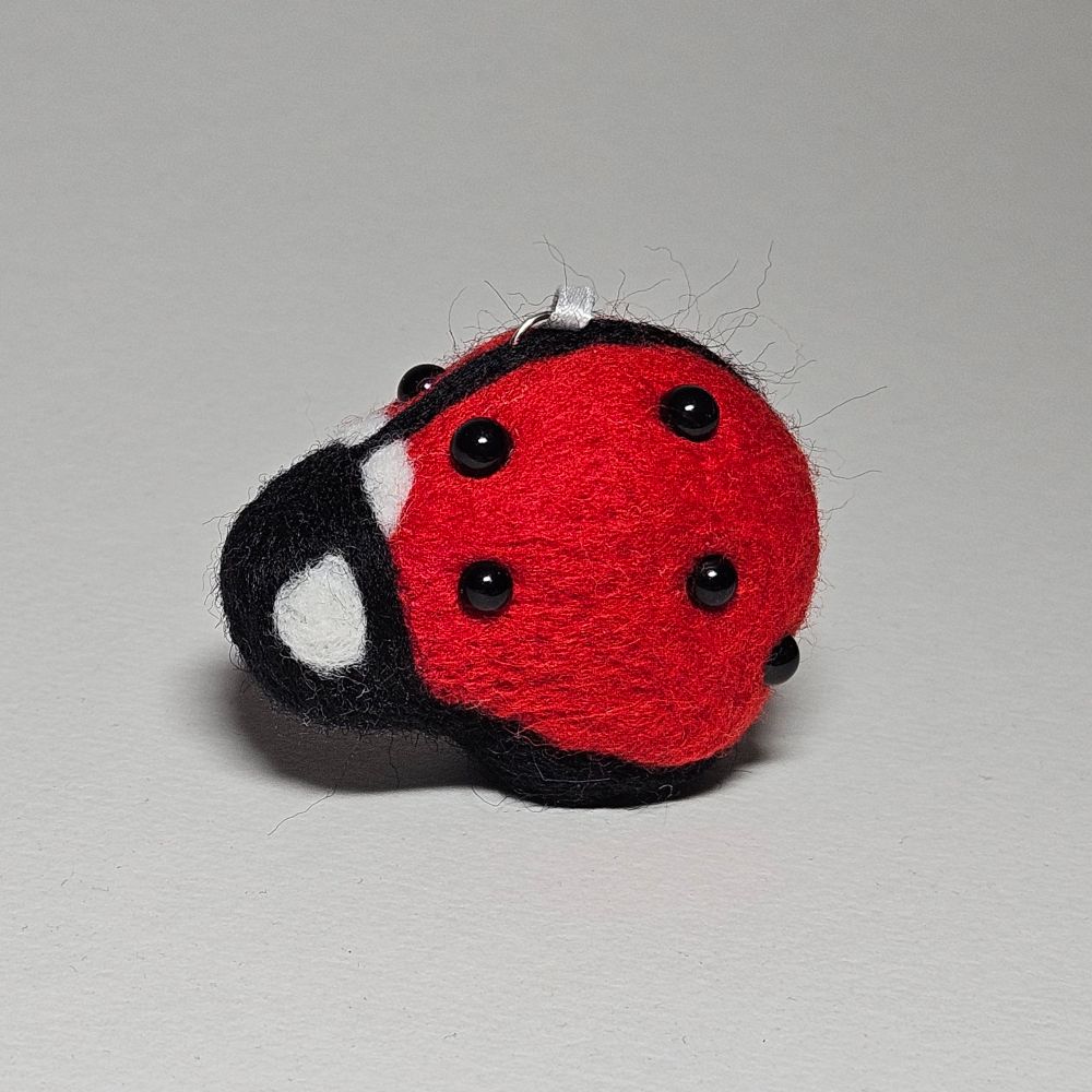 An abstract bear made with needle felting to look like a lady bug