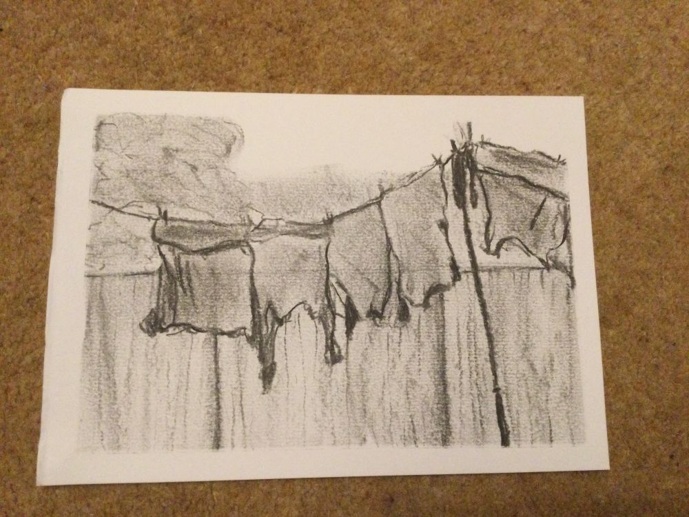 A sketch in charcoal of a washing line with clothes on it in front of a fence. Trees and hedge faintly in background. A pole holds up the line.