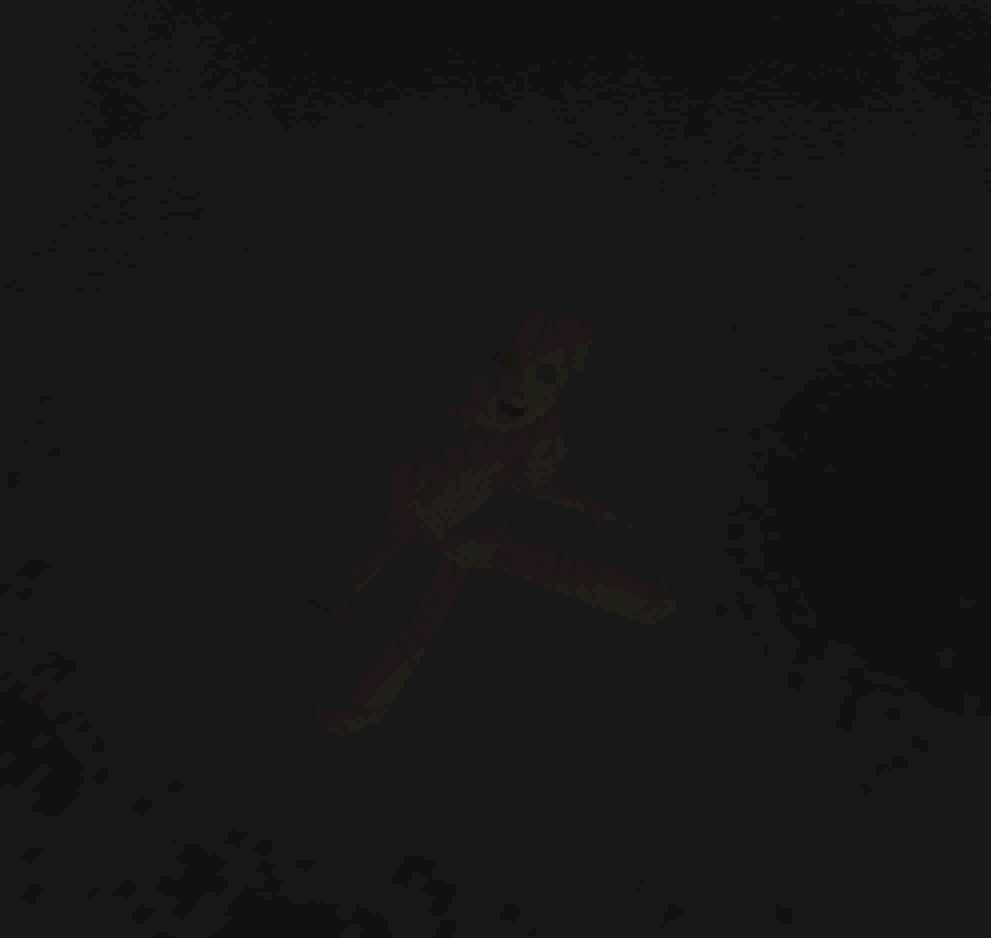 The picture shows a 3D wooden doll shrouded in darkness