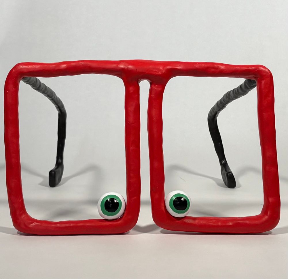 Sculpture of small eyeballs inside of large glasses. 