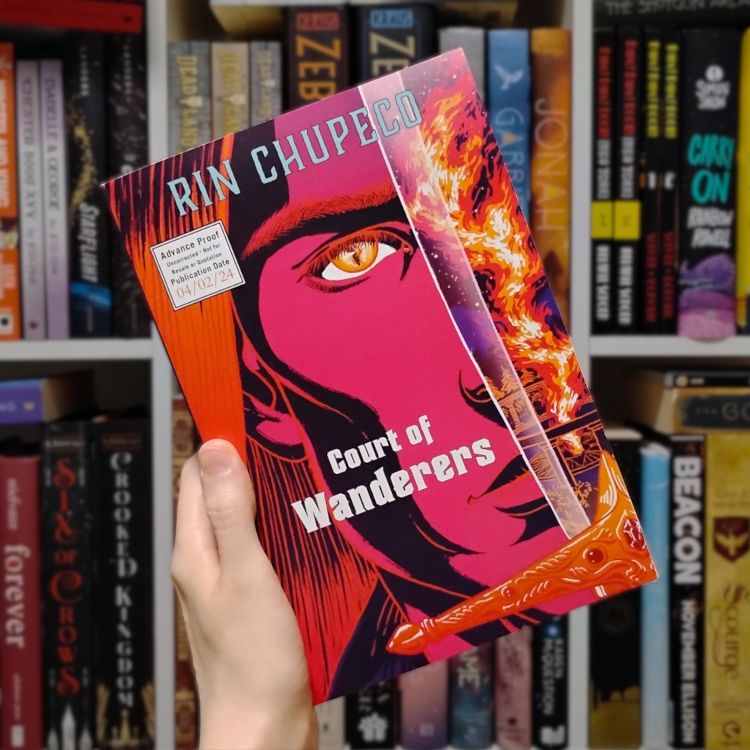 Court of Wanderers by Rin Chupeco ARC, held up in front of my bookshelf. The cover is a close-up of half a chiseled face with cheekbones for days and a slit pupil eye, facing the viewer, an upright sword covering the nose. Flames are reflected in the sword, and the colors on the whole cover are strong and vibrant with a lot of hot pink and orange.