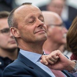 Friedrich Merz, selbstzufrieden einer Rede lauschend