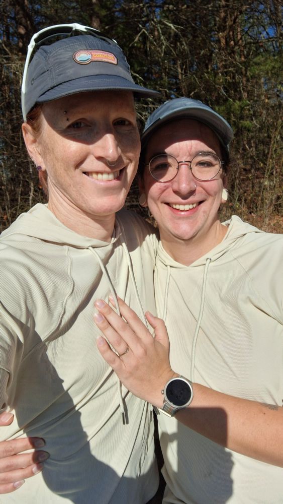 Tilda and now fianceé posing on a trail run, fiancee has a ring in her finger

they're wearing identical hoodies