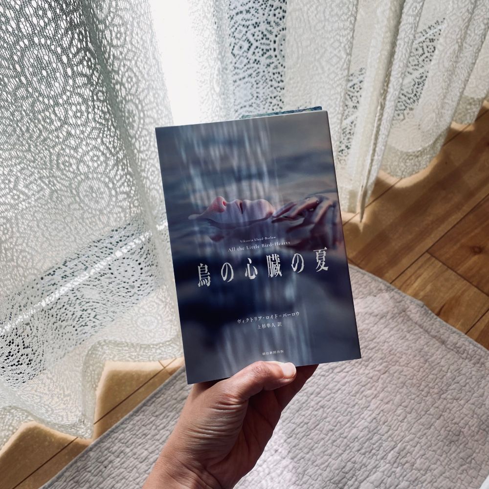 ヴィクトリア・ロイド=バーロウ(上杉隼人)『鳥の心臓の夏』朝日新聞出版
POOLによる装画は朝焼け時のような薄桃色がかった水面に人物の鼻と口元と手先だけが見える。3DCGで描かれる人物の肌はマネキンのように滑らかで非現実的。