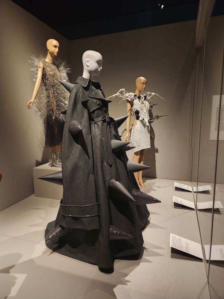 a photo of several dresses at the FIT's new exhibit, Dress, Dreams, and Desire: Fashion and Psychoanalysis. At center is a spiky black dress by Viktor and Rolf. It's awesome.
