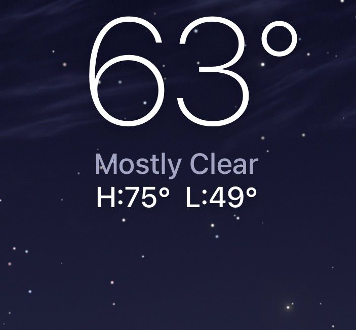 Screenshot of the Weather app for iPhone

In large, thin white numbers it says 63°.  Below that, it says "Mostly Clear" in smaller, pastel purple letters, and below that, it says H:75° L:49°.

The background is a bluish night sky with small white stars and wispy streaks of clouds