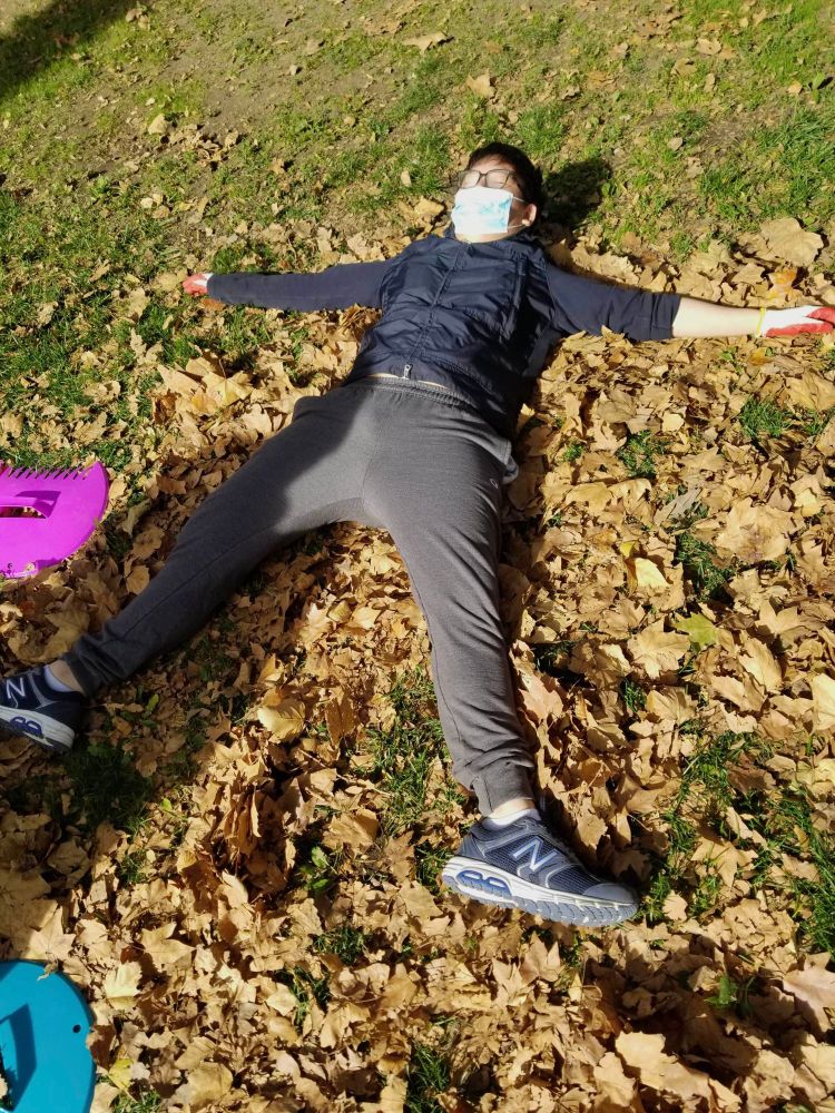 Person laying down in a pile of leaves.
