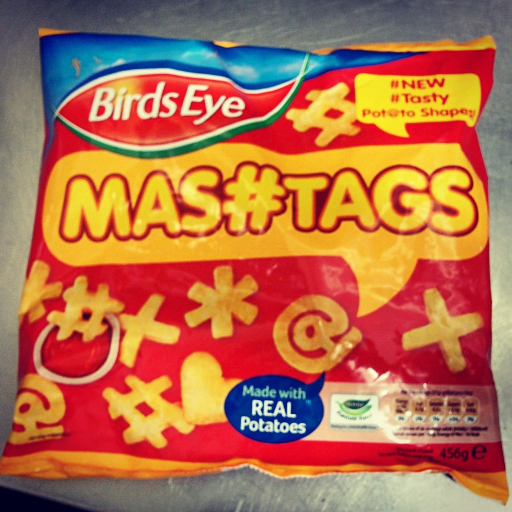 A packet of Birdseye Mashtags. A red freezer bag featuring yellow potato shaped hash, heart and at symbols. Has a stylised heading Mas#Tags and claims to be made from real potatoes.