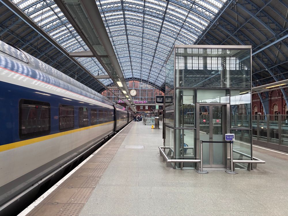 A Eurostar train on the let platform underneath the train arch of St Pancras on a near empty concourse (everyone had boarded)