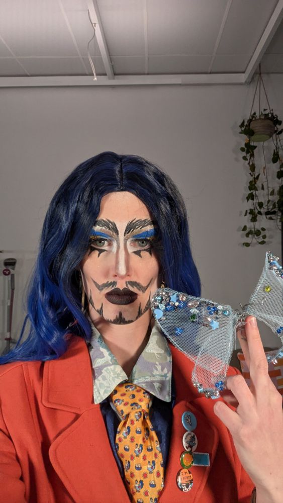 Formally dressed king with blue hair holding a blue butterfly made of wire and beads