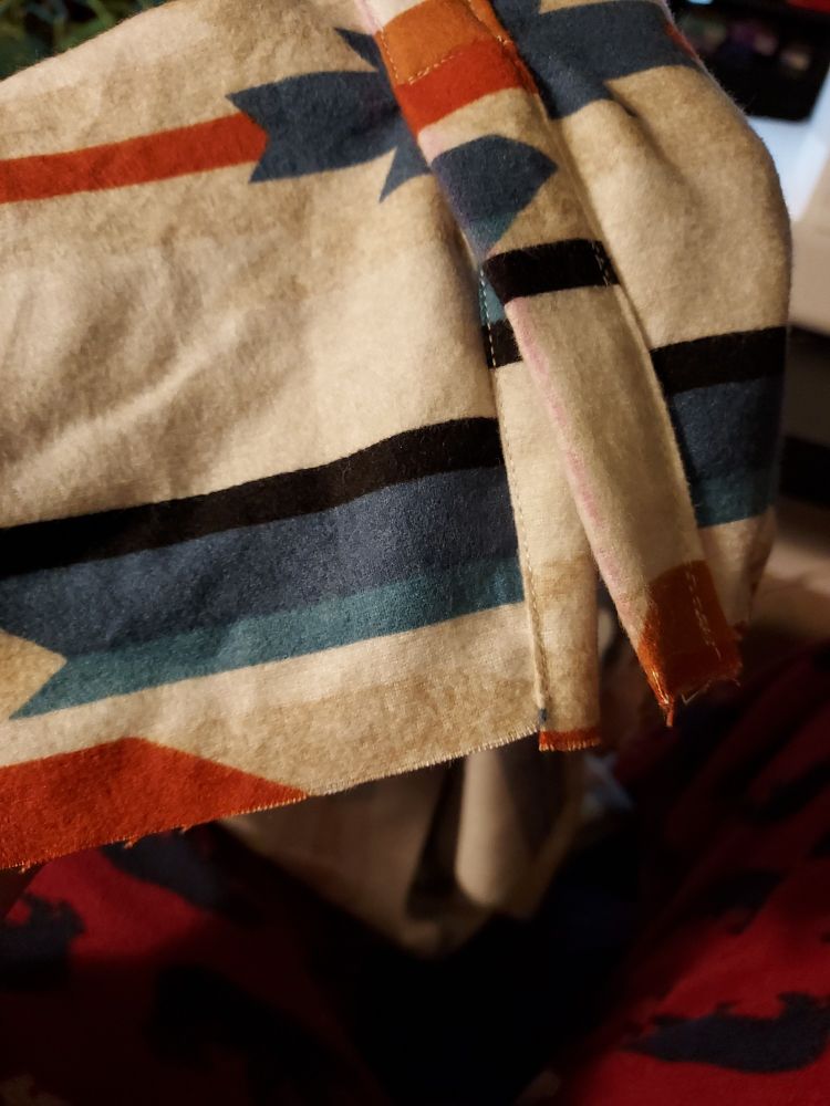 Photo of the end of a shirtsleeve in progress, showing a freshly sewn placket of middling quality