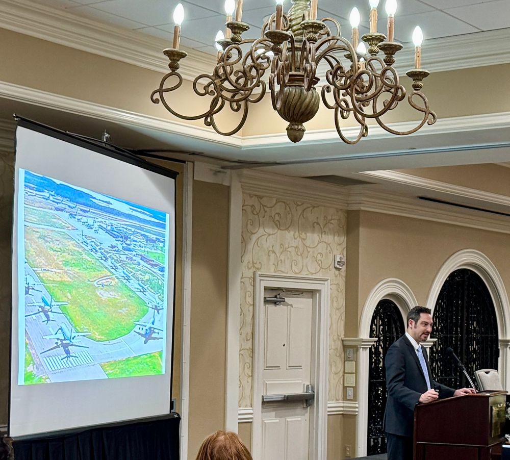 Matthew Mingle speaks at a podium 