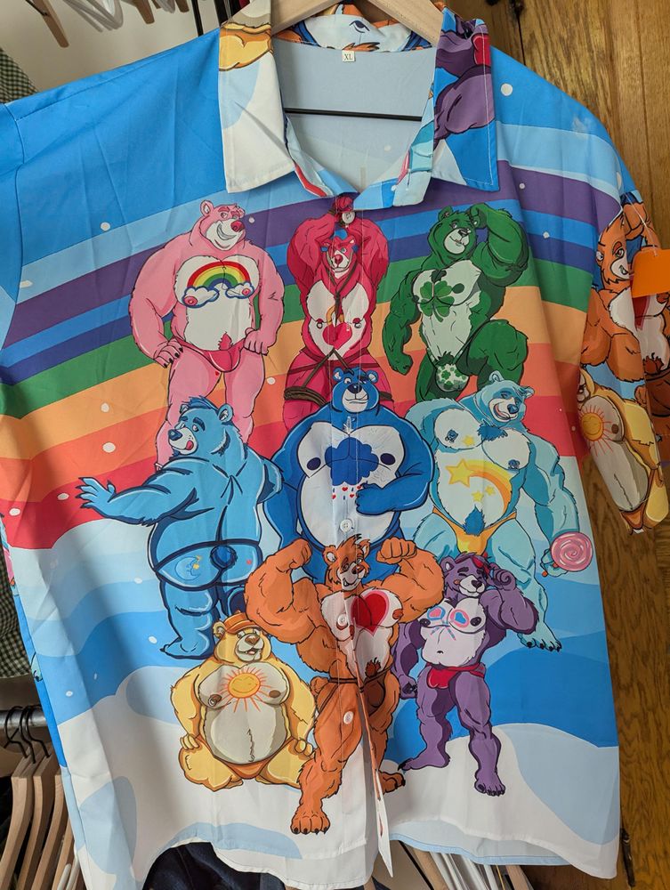 A button down short sleeve shirt printed with bright rainbow care bears, ranging from muscular to chubby, in various ropes, jockstraps, and thongs