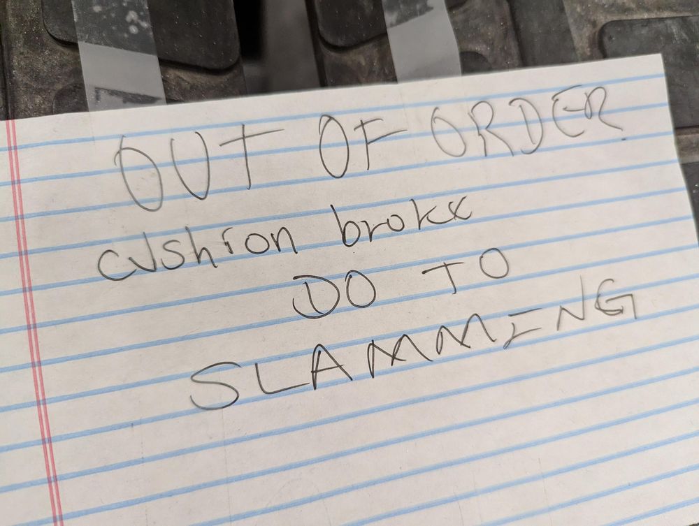 A sign on gym equipment saying "Out of order: cushion broke due to slamming"