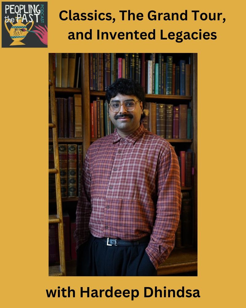 Hardeep stands in front of a bookcase filled with old books, with his hands in his pockets in a relaxed stance. He is wearing slacks and a checked shirt, and he also has glasses on.