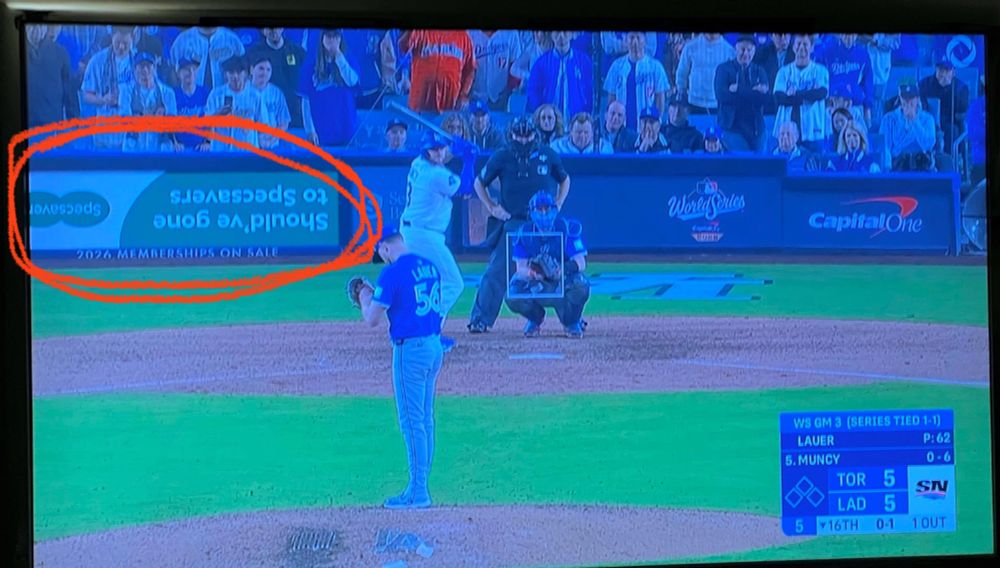 Image of a baseball game with an upside down ad in The background 