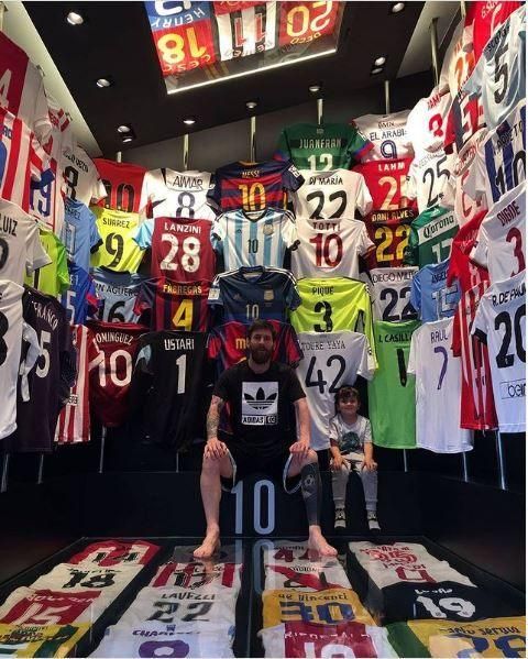 Lionel Messi sitting in front of a large closet full of soccer jerseys