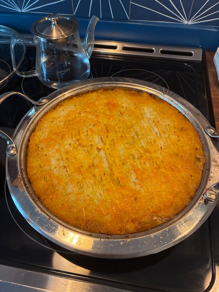 cottage pie in a round pan, fork marks on the mash. Cooked to perfection 