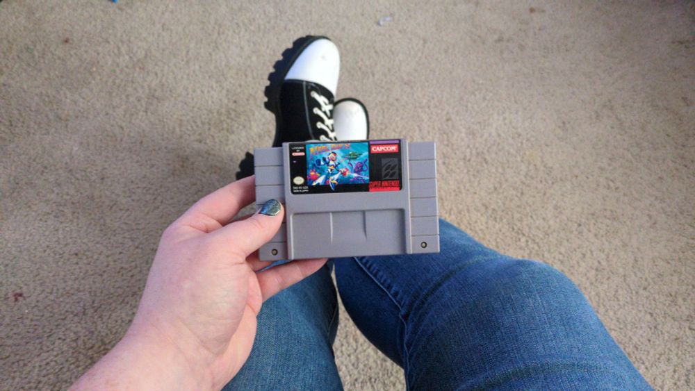 Just a girl holding her original SNES copy of Mega Man X.