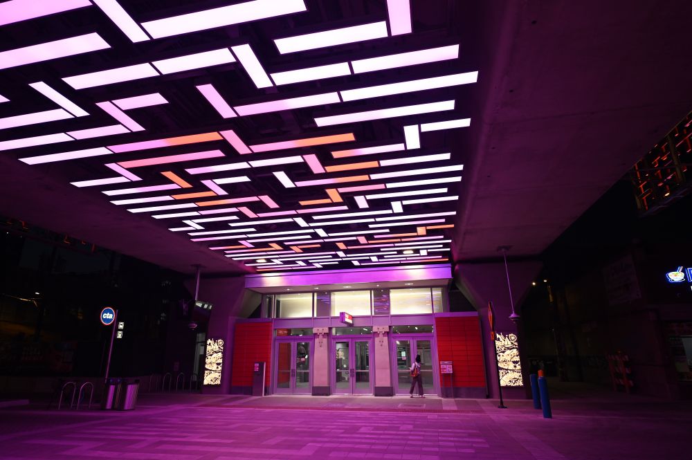 An under the station view of the Argyle station, showing the geometric pattern above in closer detail, casting a purple glow onto the brick work below