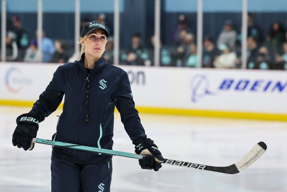 Jess Campbell holding a hockey stick cross body.