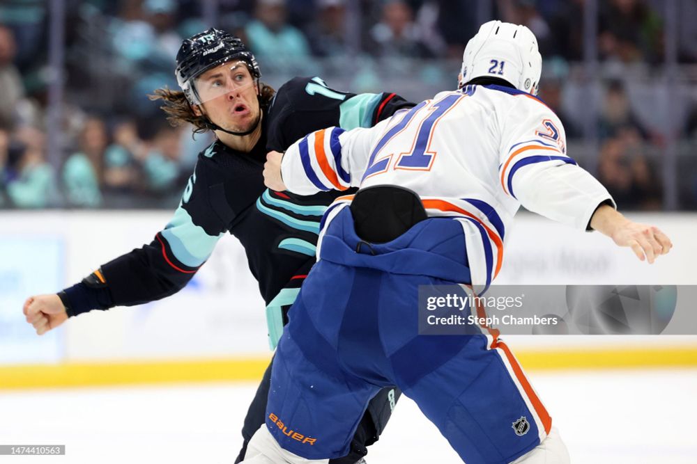 John Hayden, Kraken uniform, on the ice, getting ready to punch an oiler, pulling a funny face. 