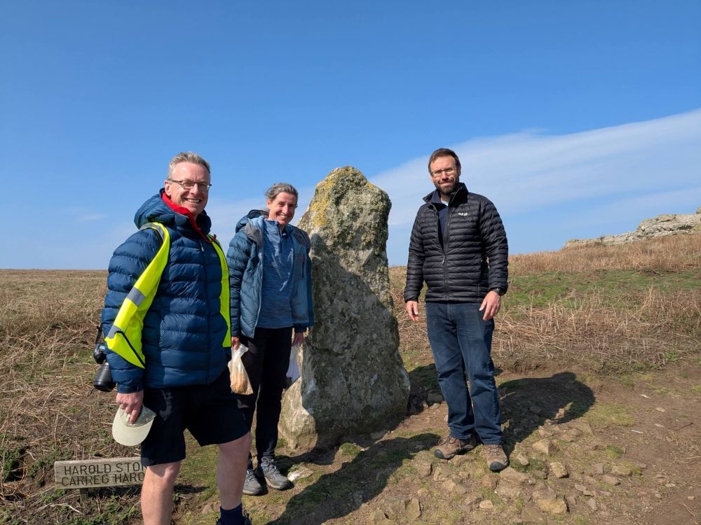 3 archaeologists standing with the Harold Stone.