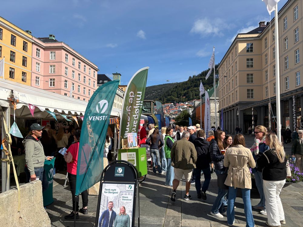 Norwegian candidates and political parties campaign side by side in front of kiosks on a Bergen plaza. 