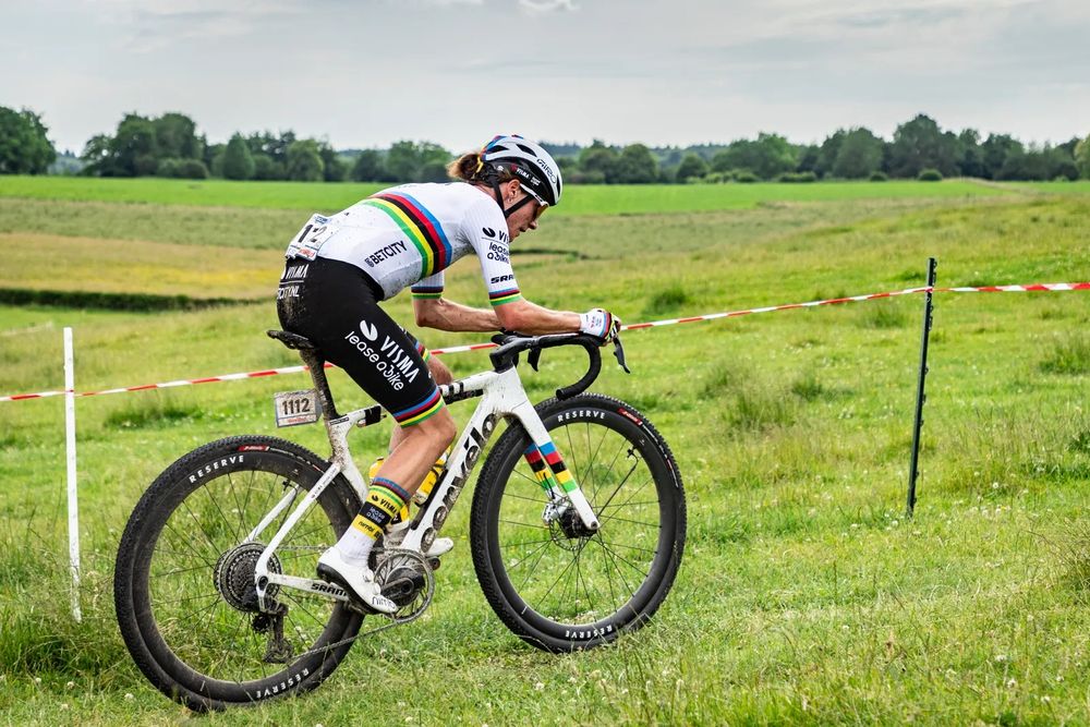 A closer up view of the gravel racing bike that has yet to be released by Cervelo. Professional cyclist Marianne Vos is again pictured as she races to victory at 3RIDES gravel race in Aachen, Germany. The bike is a white Cervelo frame with a black-lettered logo. Its design features an aerodynamic focus in its tube shapes, and it has special world championship livery with stripes on the fork to respect the bike's rider.

Photo by Leon Van Bon