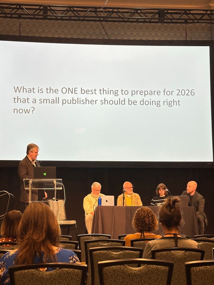 Four speakers at the Charleston conference in front of a screen with text that reads “what is one best thing to prepare for 2026 that a small publisher should be doing right now?” 