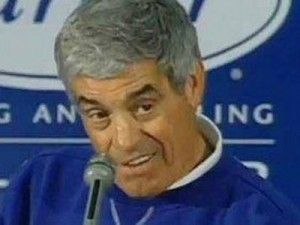 Close up of Jim Mora, former football coach, in the middle of a press conference. Jim has been coaching a mediocre NFL team, and has just been asked a question regarding his team's playoff chances. His face shows surprise, amusement, and disgust in equal measure. Also holy shit he looks like Phil Leotardo lmao thats great I never noticed that before. This man is definitely a repressed homosexual. Maybe.
