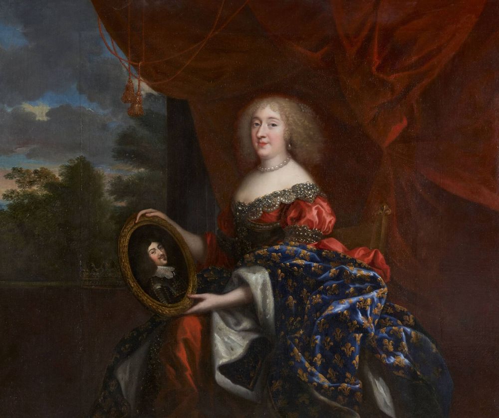 Cette œuvre représente Anne-Marie-Louise d’Orléans, duchesse de Montpensier, également connue sous le nom de "La Grande Mademoiselle". Il s’agit d’un portrait de style baroque, probablement peint au XVIIe siècle.
Disposition et posture : Elle est assise sur un fauteuil richement décoré, légèrement tournée vers la droite. Son corps est droit, dans une posture noble et confiante, les épaules dégagées. Son visage est clair et calme, dirigé vers le spectateur avec un léger sourire.
Visage et coiffure : Anne-Marie-Louise a une peau claire, un visage arrondi, et des joues légèrement rosées. Ses cheveux sont blonds, bouclés et tombent jusqu’aux épaules, encadrant son visage. Elle porte un collier de perles autour du cou.
Vêtements : Elle est somptueusement vêtue. Sa robe est riche en textures et en couleurs : Le corsage est rouge éclatant avec des manches bouffantes, bordé de bijoux. Le bas de la robe est bleu foncé, décoré de motifs dorés en forme de fleurs de lys, symbole royal français. Une étoffe blanche satinée dépasse sous la robe, ajoutant au luxe de sa tenue.
Accessoires et symboles : Elle tient un grand médaillon ovale dans sa main gauche. Ce médaillon contient un portrait d’homme, probablement le roi Louis XIV ou un membre de la royauté française. Elle le tient délicatement, appuyé sur ses genoux, dans un geste d’attachement ou d’hommage.
Décor et ambiance : L’arrière-plan est partagé : À gauche, une fenêtre ouverte laisse voir un paysage avec des arbres, un ciel bleu et quelques nuages. À droite, un grand rideau rouge foncé encadre la scène, créant une atmosphère de théâtre ou de palais. Le rideau est drapé de manière luxueuse, renforçant l’impression de richesse.
Ambiance générale : La scène dégage une impression de noblesse, de puissance tranquille et de richesse. Le contraste entre le bleu profond de la robe et le rouge chaud du rideau donne de la profondeur et du drame à l’image.
