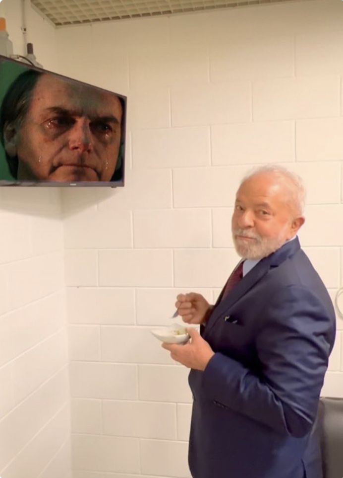 montagem do Lula comendo e rindo, olhando para a televisão com a cara de Bolsonaro chorando.