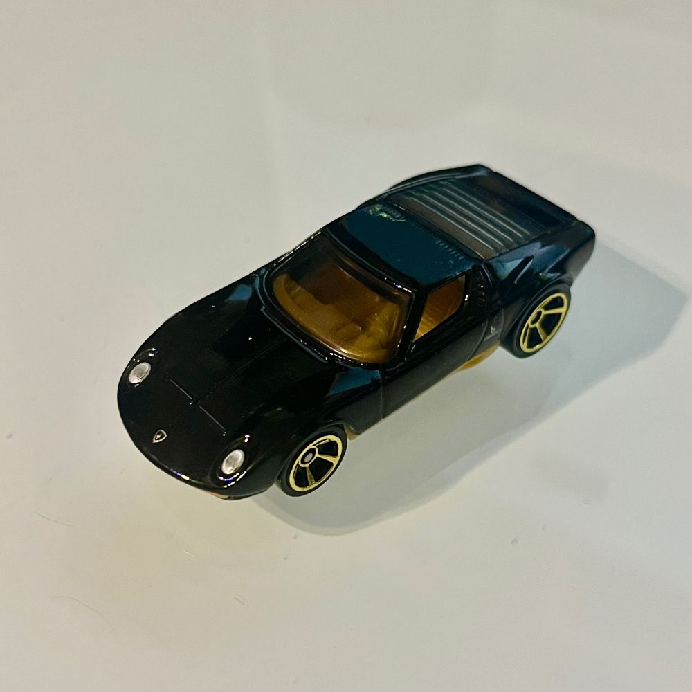 Black figurine of a '71 Lamborghini Muira with gold trim
