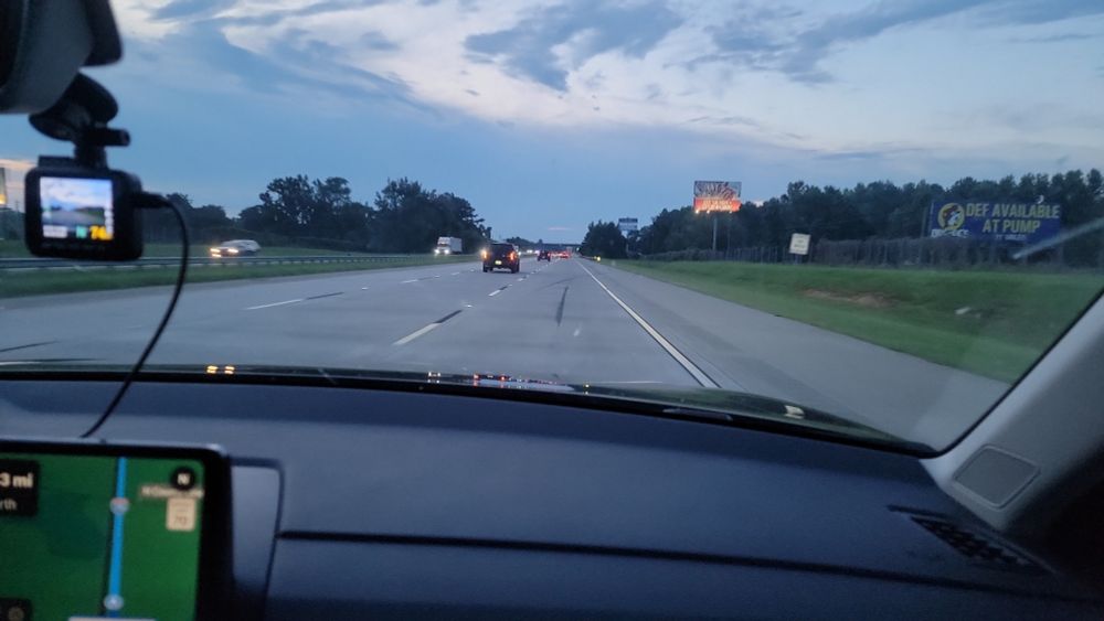 a picture of the open Georgia road, only a couple cars, dark cloudy sky, and some street signs