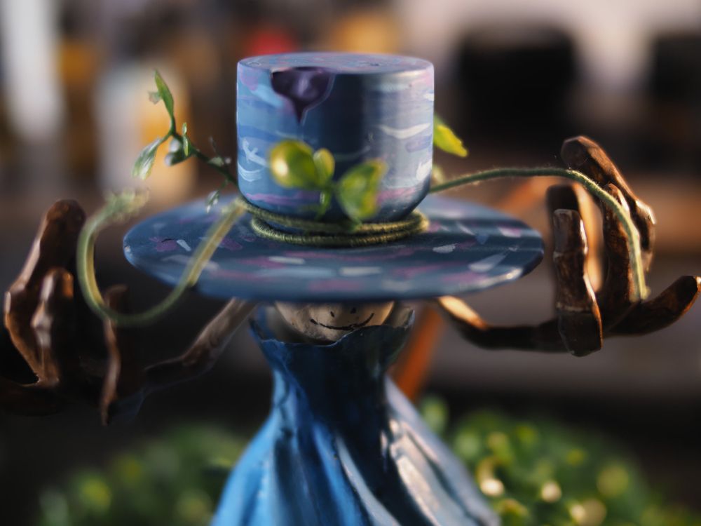 A hand painted, 3D printed figurine of Stray Hatty from video game Infinity Nikki, dramatically staring into the camera