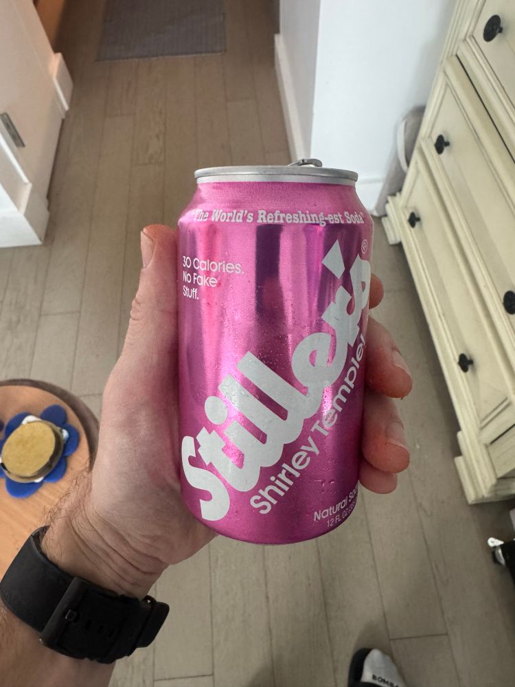A hand holding a can of Ben Stiller’s Shirly Temple soda