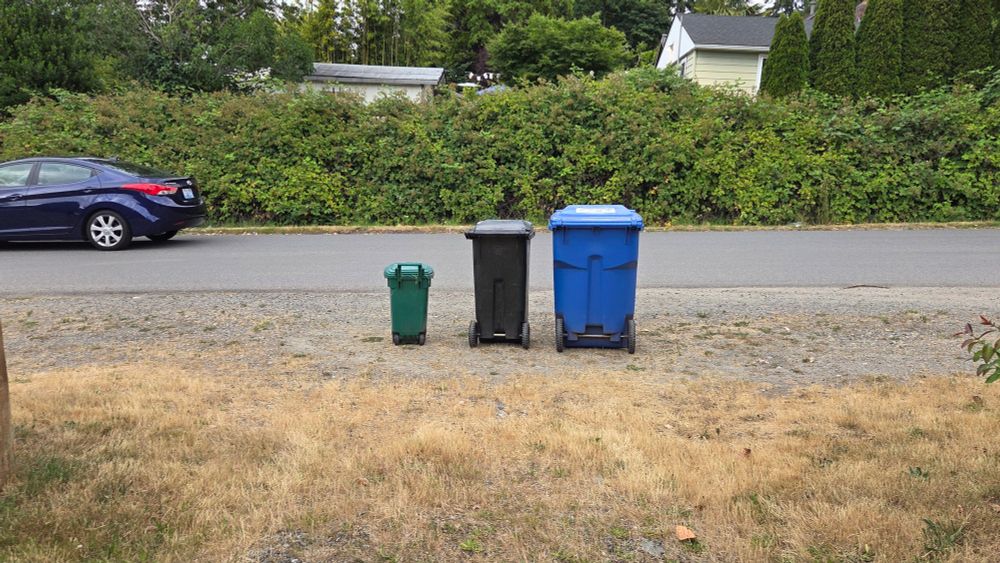 Three garbage bins lined up by height waiting for the garbage truck to come