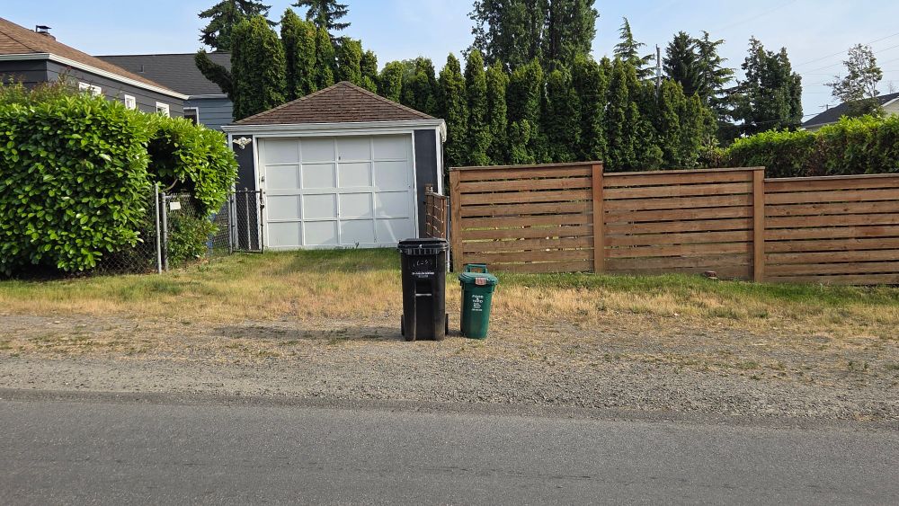 2 garbage bins waiting at the curb