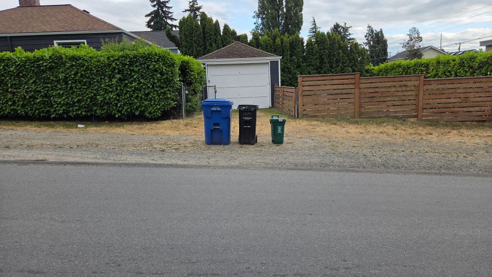 Three garbage bins lined up by height waiting for the garbage truck to come