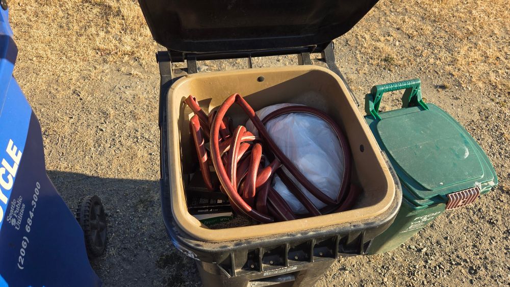 Open garbage bin showing an old cut up hose inside