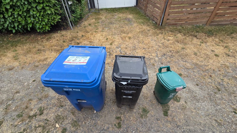 Three garbage bins lined up by height waiting for the garbage truck to come