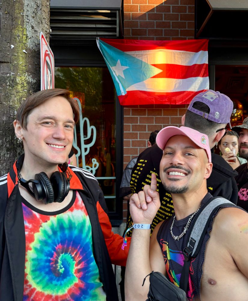 A picture of me in Seattle pausing by a Puerto Rican flag on the side of a building.
